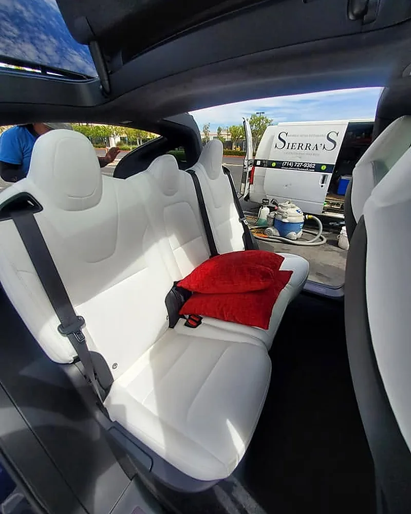 Clean Tesla interior with the Sierra's mobile detailing van visible outside